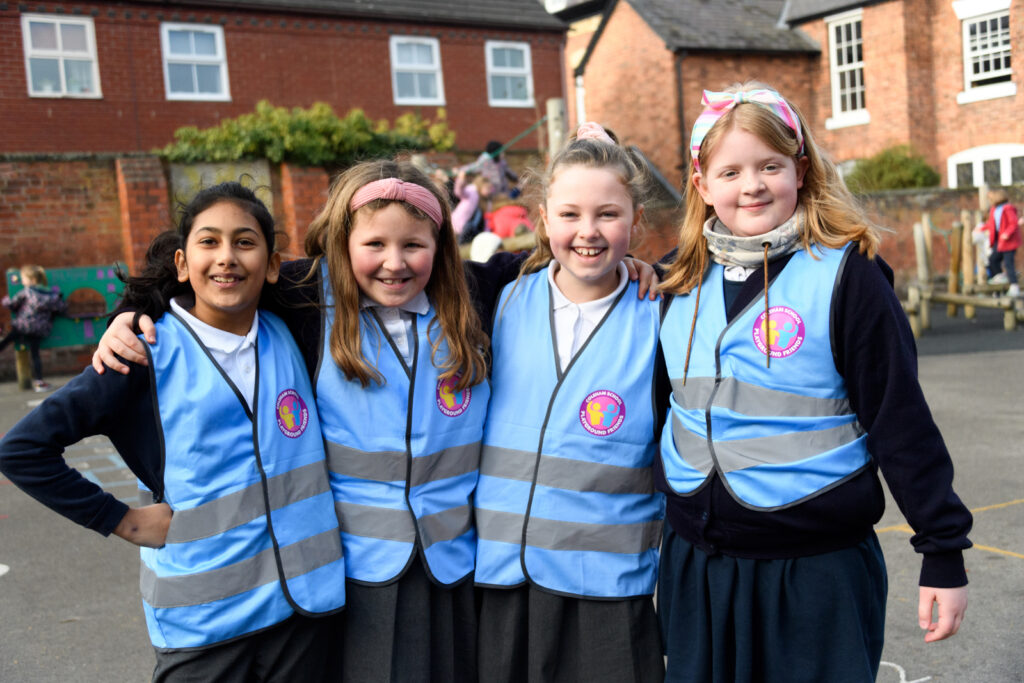 picture of four students with arms around eachother in the playground