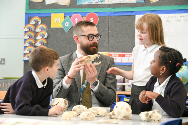 teacher showing skulls of animals to children