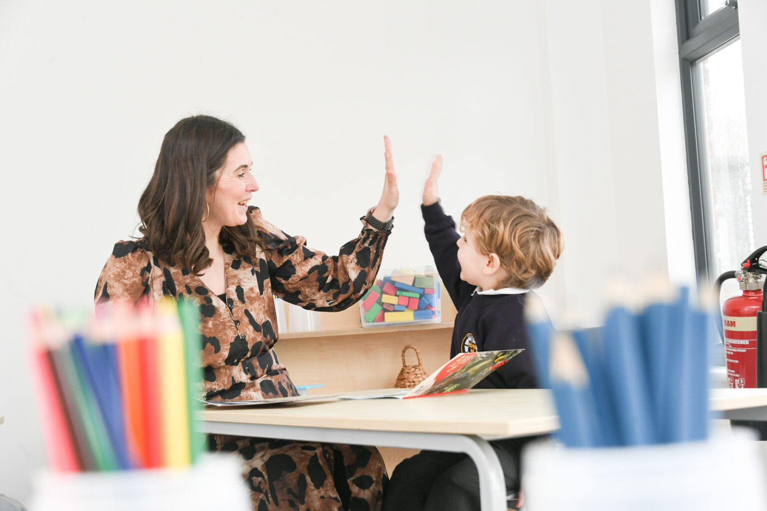 teacher and student high fiving in class