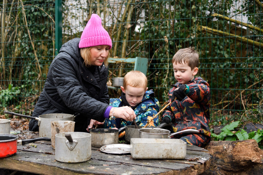 a picture of a teacher and students playing with pots and pans