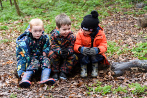 a picture of three students sitting down on the grass