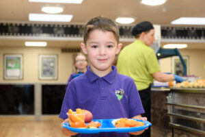picture of a student in the dinner hall wiith his food tray
