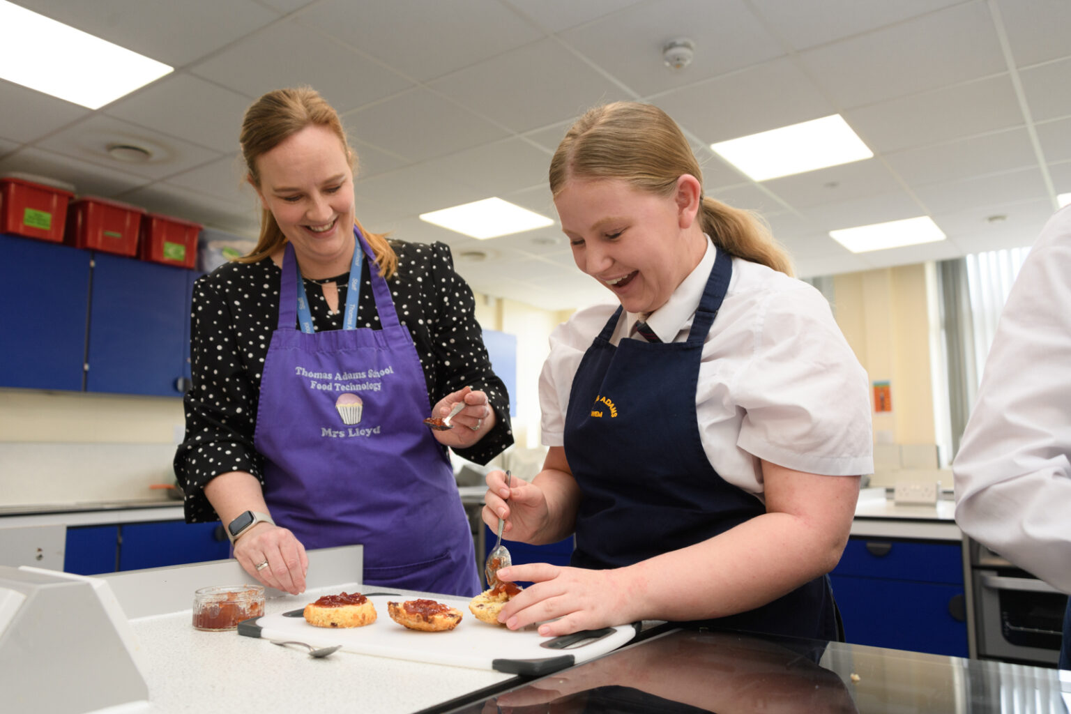 a student and a teacher working on the food the student has made in catering class