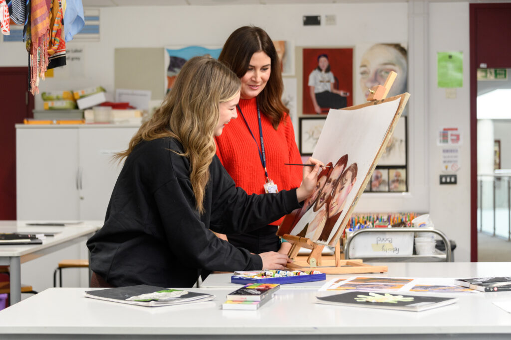 a picture of a student painting a picture with a teacher watching