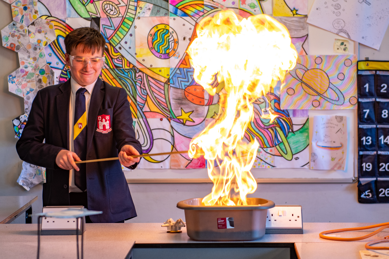 student doing an experiment in class with safety equipment on