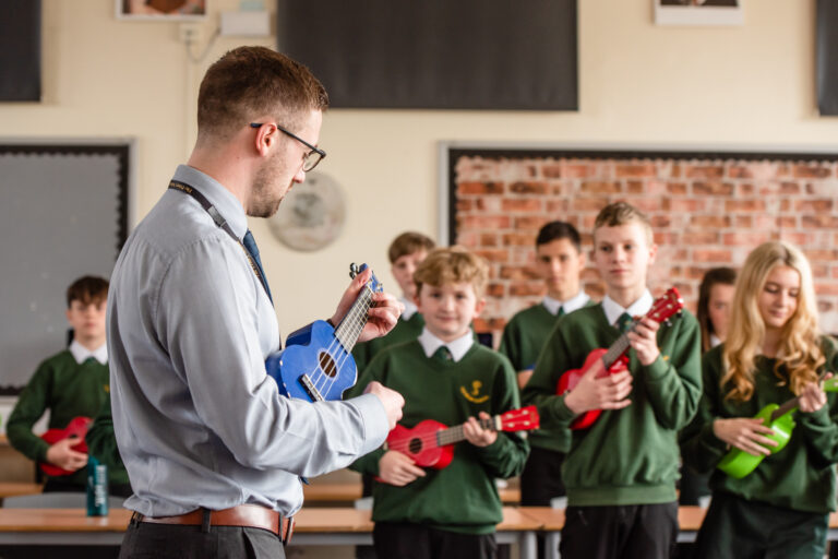 teacher showing the students how to play ukalele