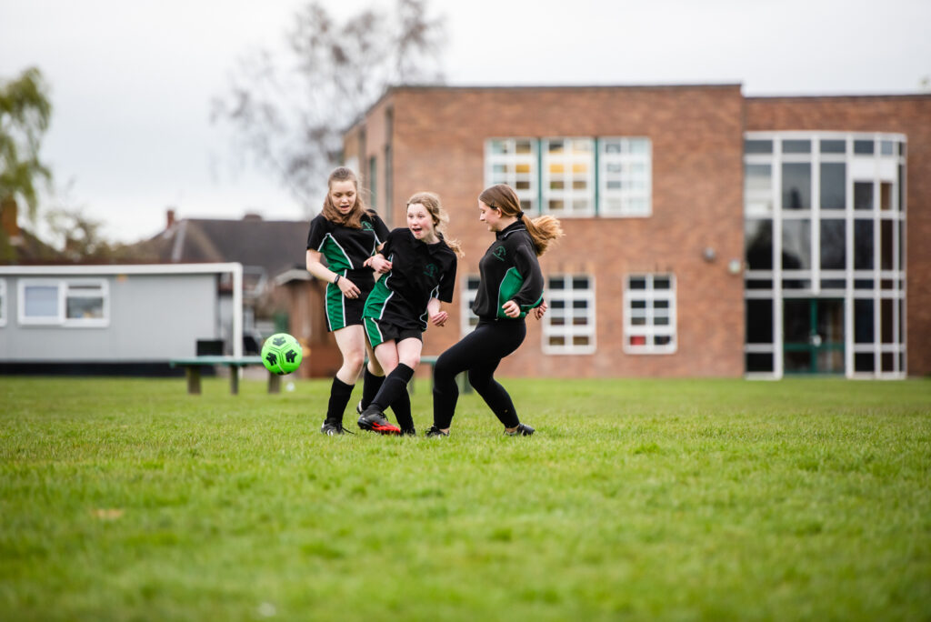 a picture of three students playing football