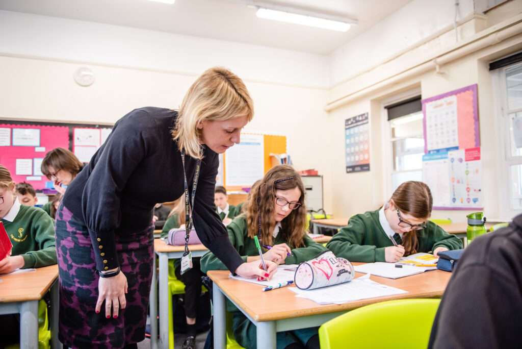 teacher helping a student with their work in class
