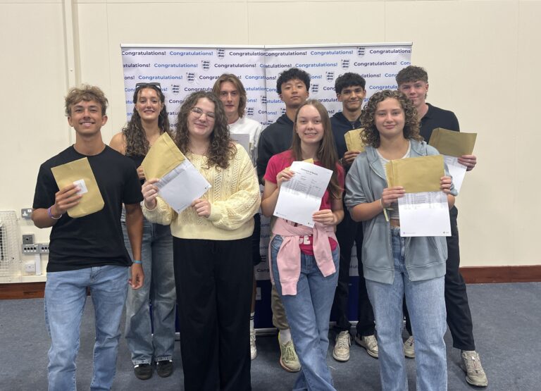 Group of nine students with GCSE results at Thomas Adams School