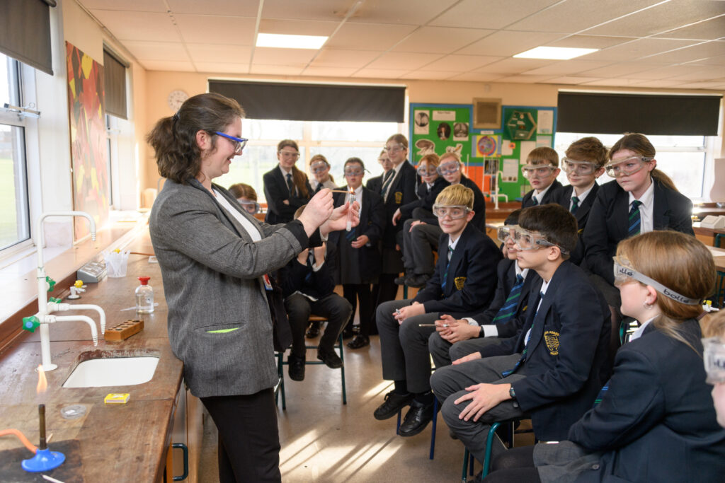 Teacher teaching a large group of pupils in a laboratory